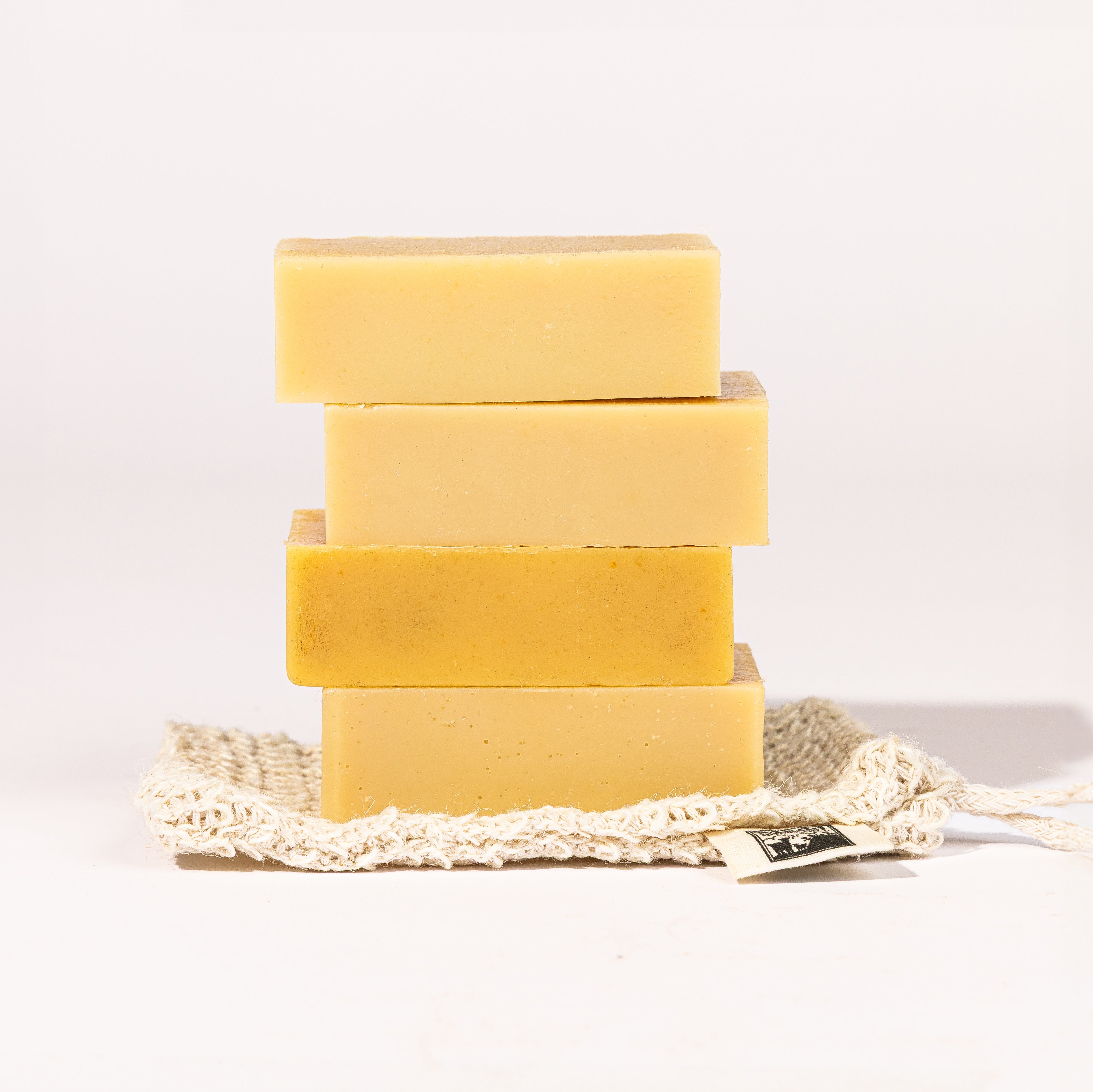 Madd House Hill Udder Maddness Goat Milk Soap Sack — four unwrapped handmade soap bars stacked on a natural cotton mesh soap sack, all-natural goat milk soap, 4oz each