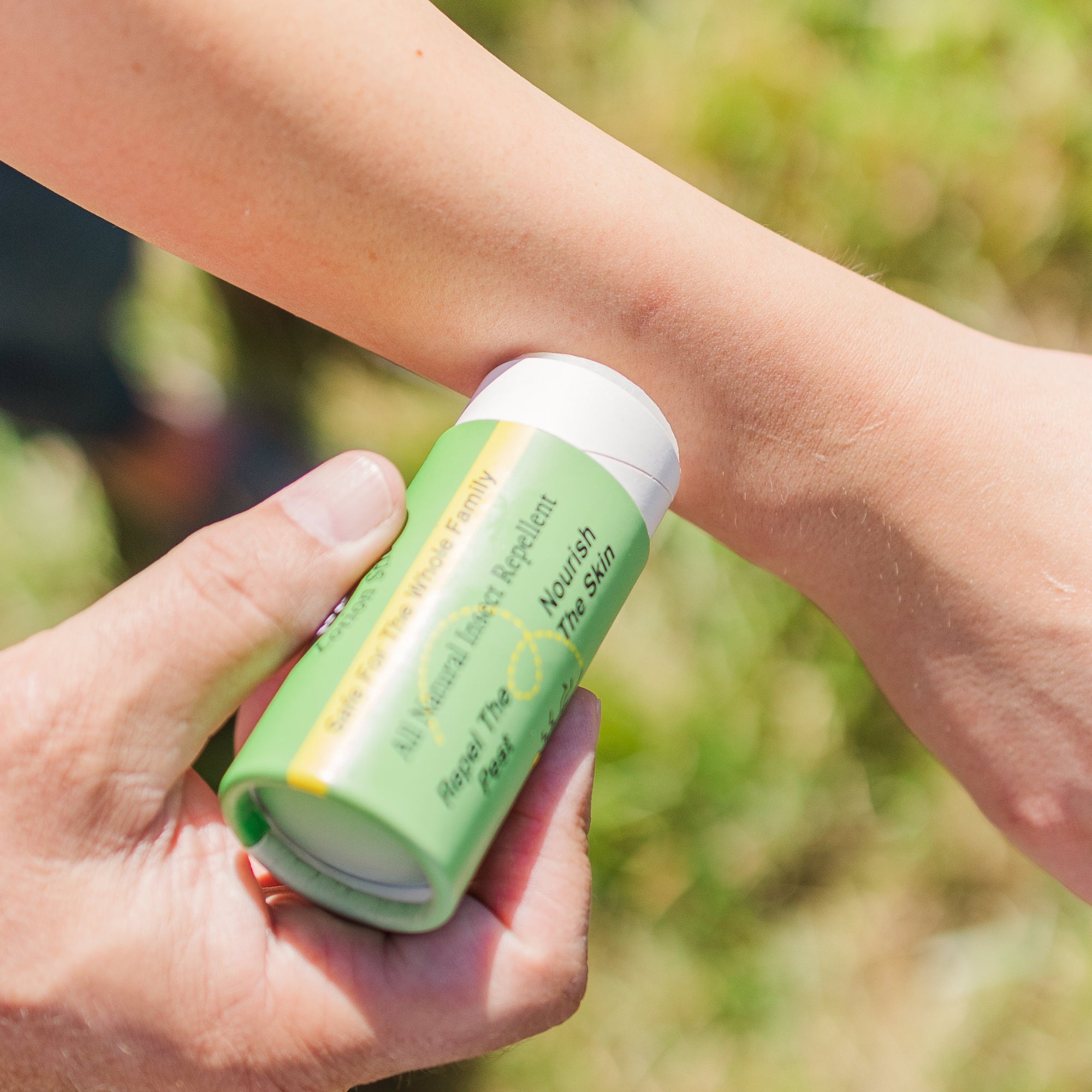 Madd House Hill Udder Maddness All Natural Insect Repellent Lotion Stick — being applied to arm outdoors, DEET free, safe for whole family