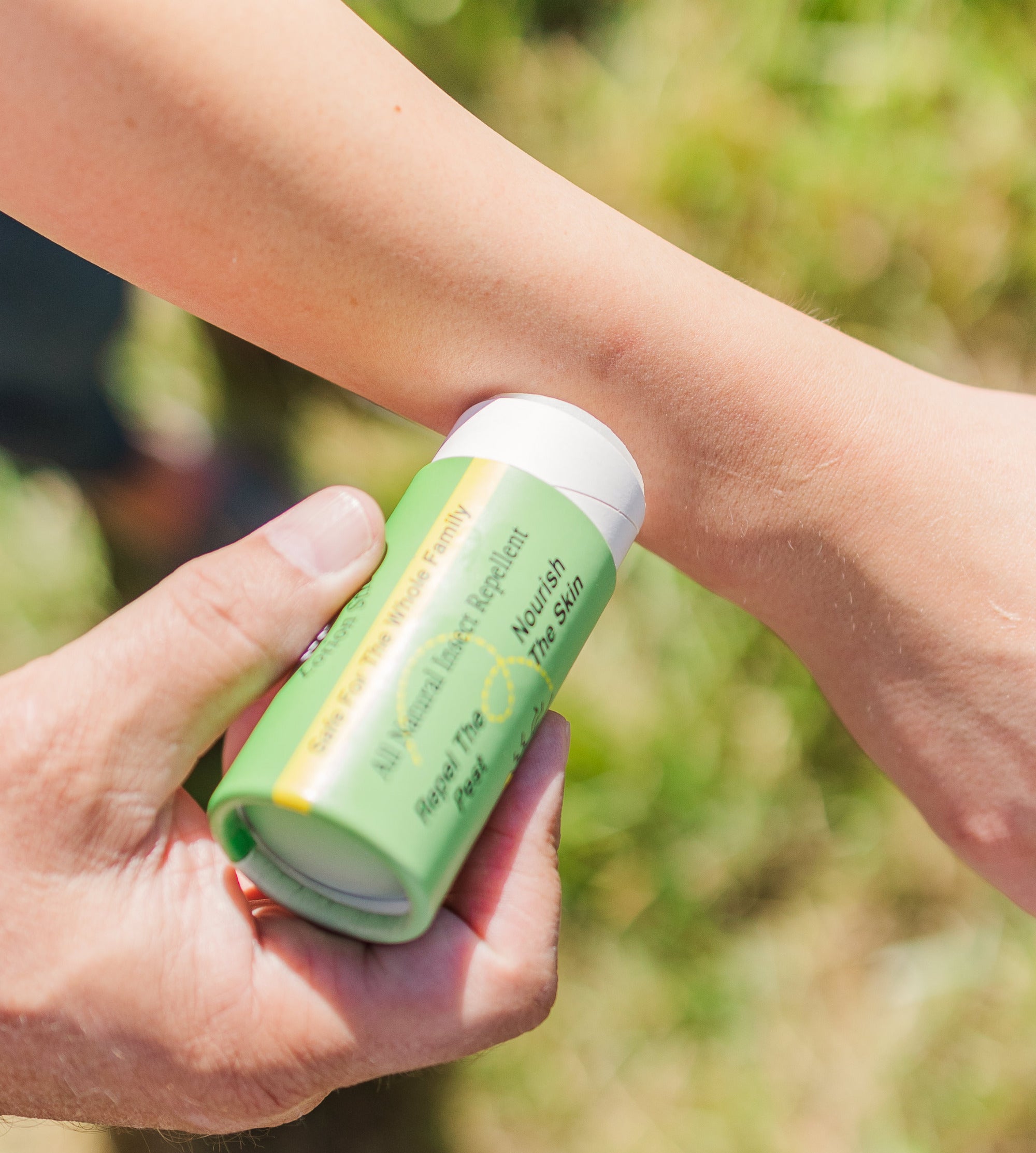 Madd House Hill Udder Maddness All Natural Insect Repellent Lotion Stick — being applied to arm outdoors, DEET free, safe for whole family